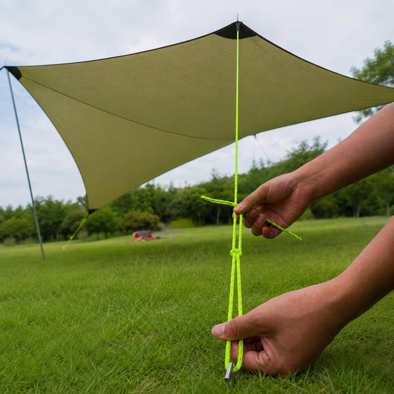 Tarp tensioned with green rope in an outdoor area